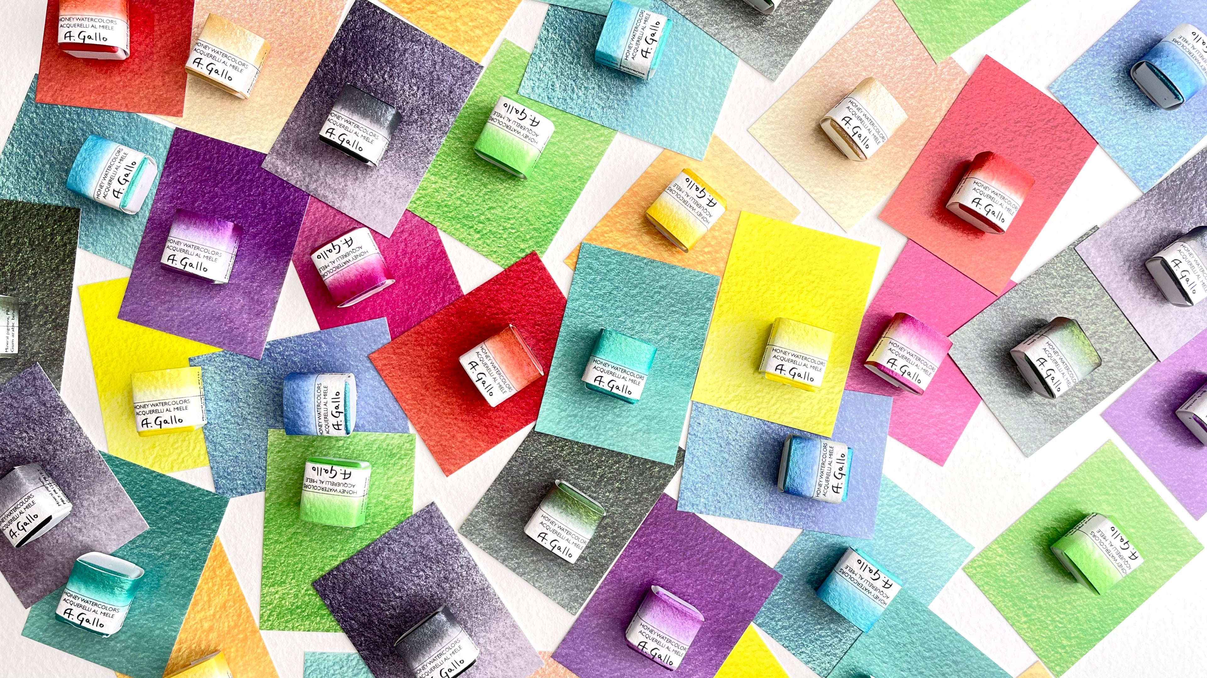 Handmade A. Gallo iridescent watercolor pans displayed on textured paper swatches"