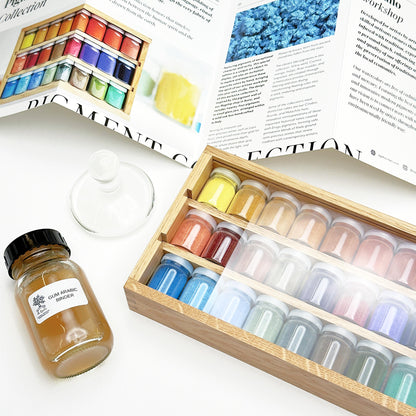Set of colorful paint jars in a wooden box on a collector brochure background