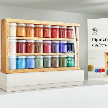 Wooden shelf with colorful jars of pigments and a 'Pigment Collection' sign in the background.